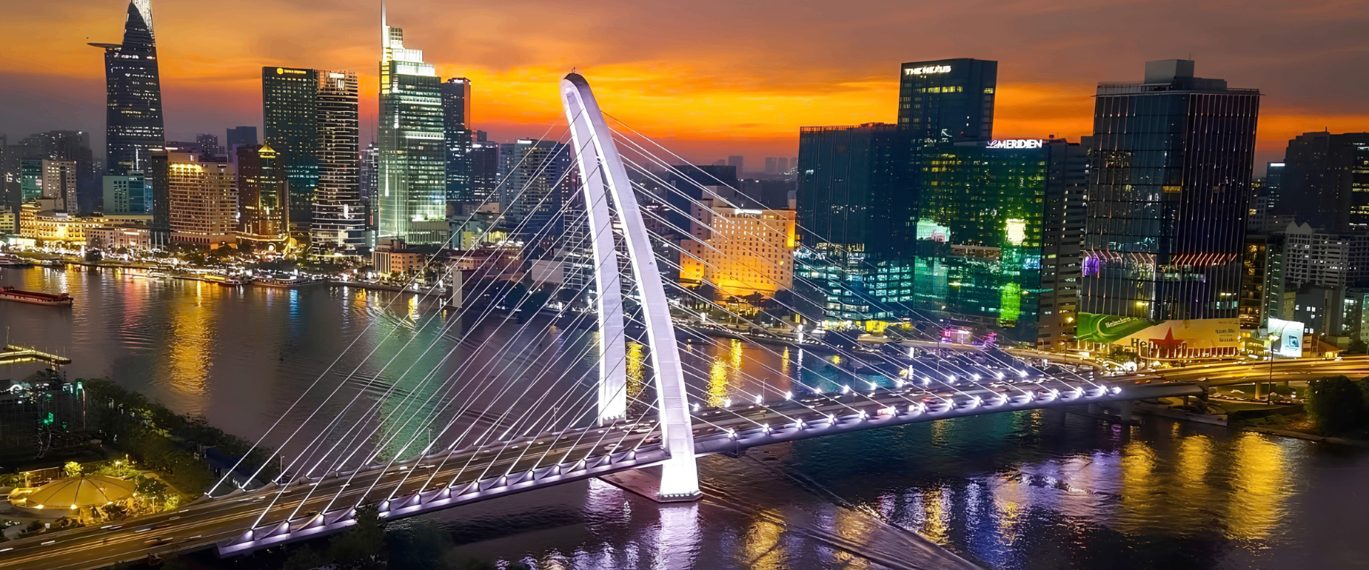 Saigon skyline glowing at sunset over the river.