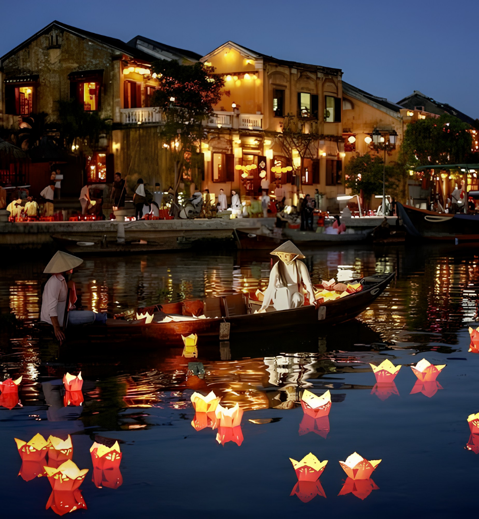 Lantern-lit Hoi An river at night with boats and floating candles.