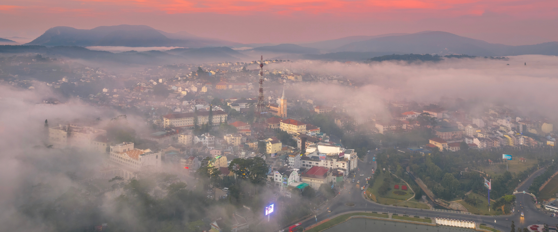 Panoramic Da Lat cityscape wrapped in mist at sunrise.